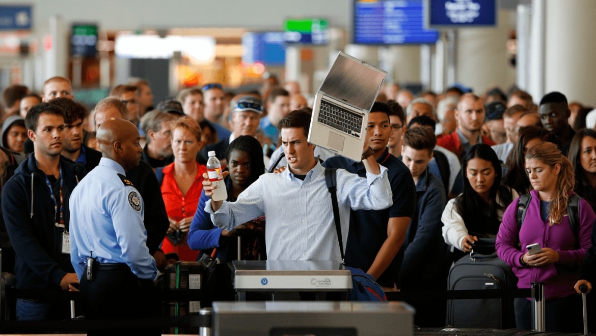Passengers at an airport security checkpoint near a body scanner