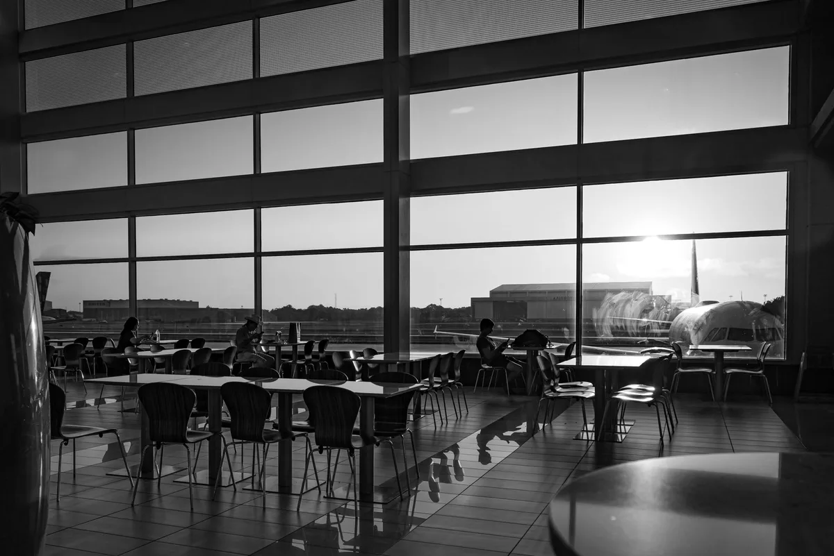 Terrasse extérieure d'aéroport avec sièges et vue sur les pistes