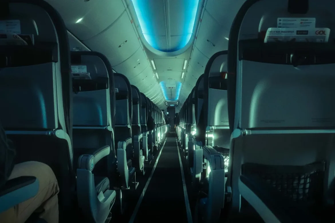 Cabine d'avion avec sièges business allongés et section premium economy visible en arrière-plan