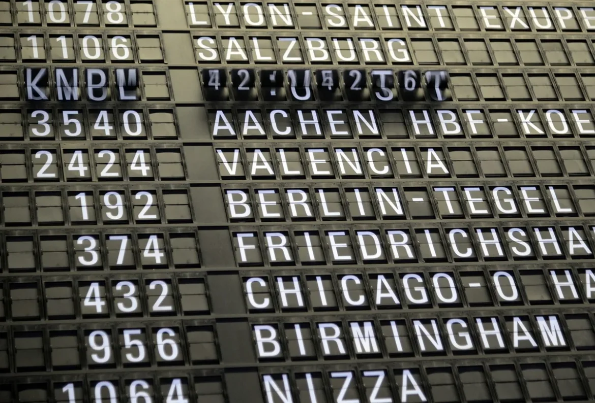 Voyageurs avec bagages dans un terminal aéroportuaire moderne, panneaux d'affichage des vols visibles