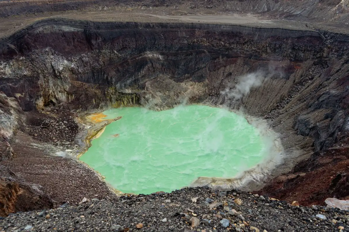 Randonnée sur les roches volcaniques noires avec vue sur le cratère et les fumerolles