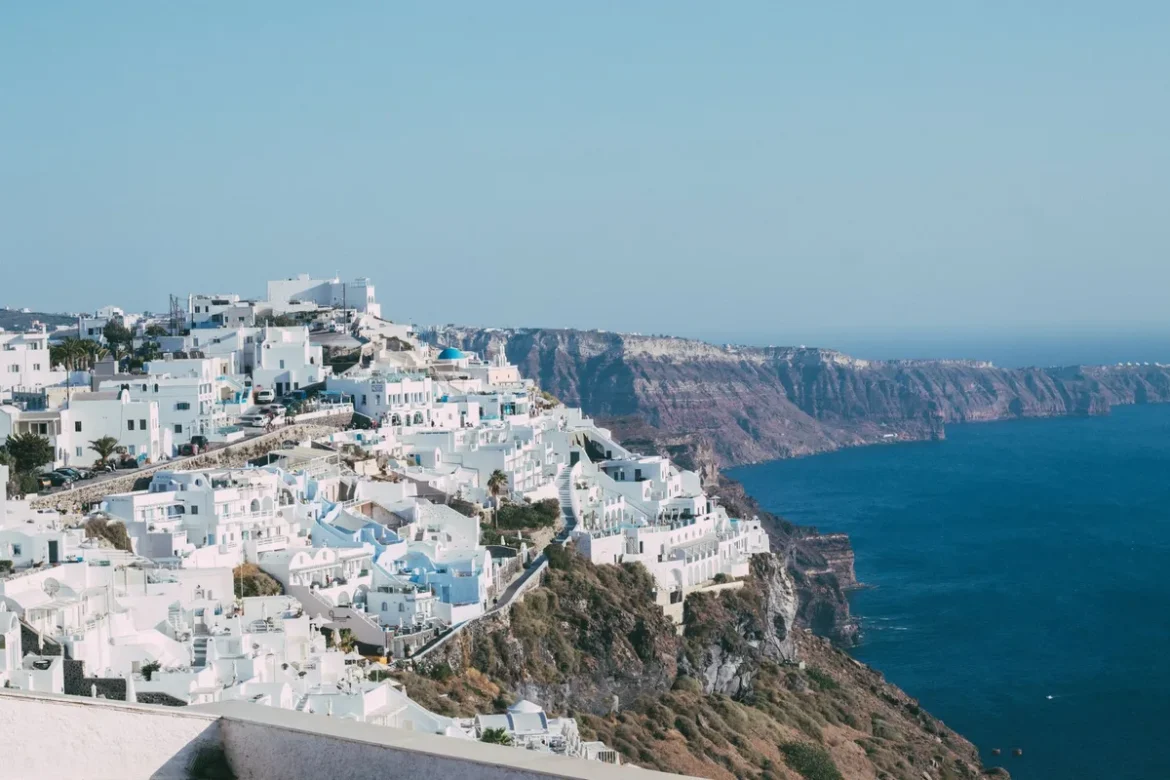 Maisons blanches et dômes bleus de Santorin surplombant la caldeira au coucher du soleil