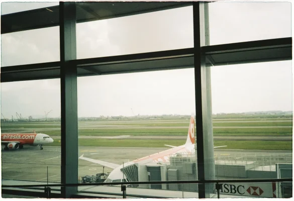 Passager regardant par la fenêtre d'un aéroport un avion long-courrier sur le tarmac