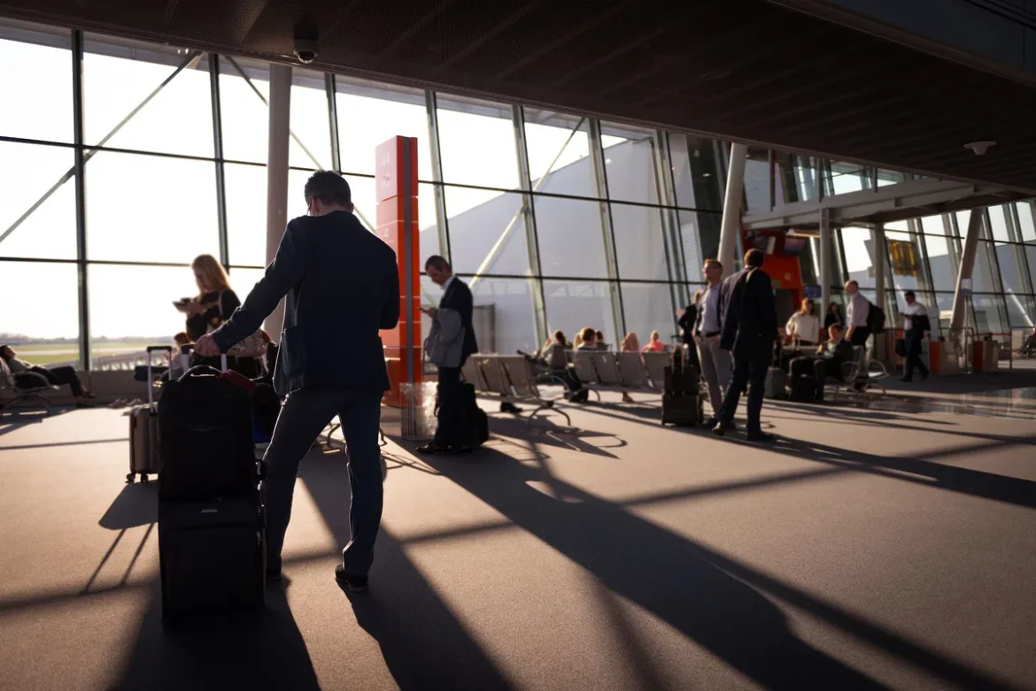 Famille à l'aéroport avec des valises colorées et des enfants tenant leurs sacs à dos