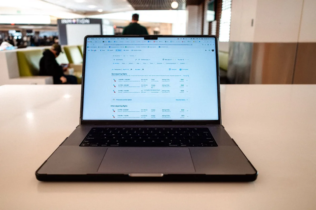 Passager effectuant une réservation de vol sur un ordinateur, comparant les options tarifaires