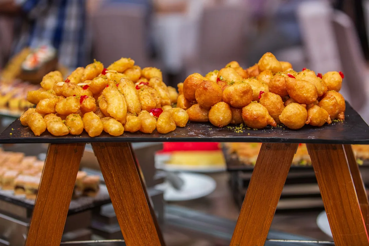 Assortiment de beignets frits et panzerotti dorés servis en cornet papier