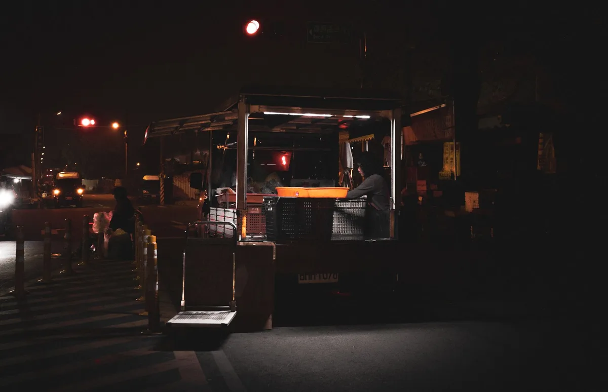 Marché nocturne animé avec camions et vendeurs sous les lumières