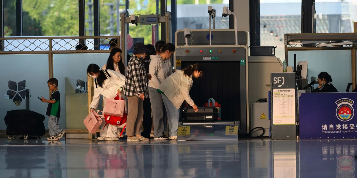 Passagers en file d'attente au contrôle de sécurité, préparant leurs bagages et liquides.