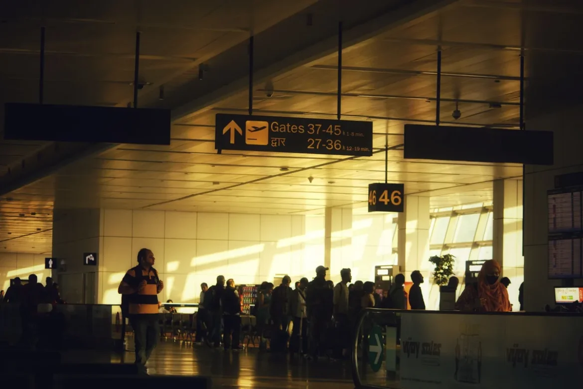 Contrôle de sécurité dans un aéroport avec passagers en file d'attente devant des postes de détection.