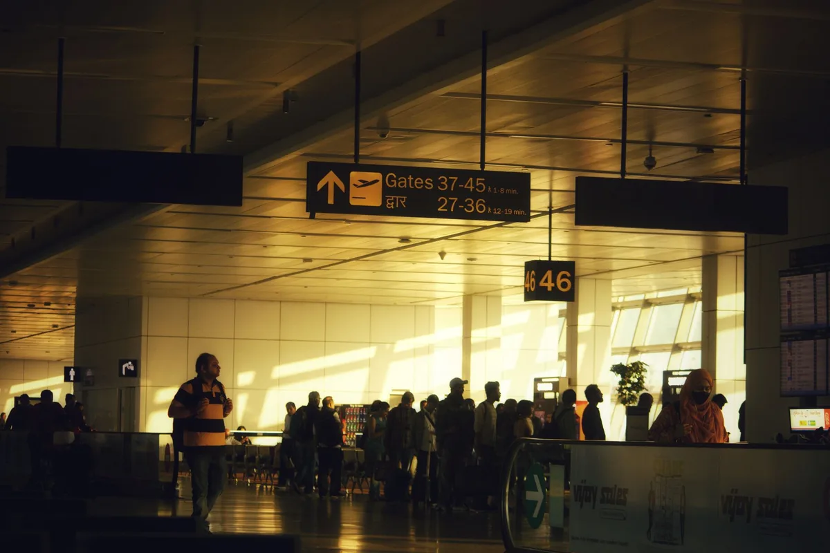 Passagers circulant dans une jetée d'aéroport moderne avec portes d'embarquement