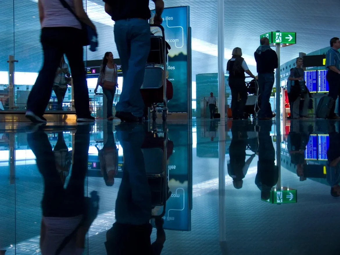 Hall d'aéroport avec tableau d'affichage des vols et passagers en attente