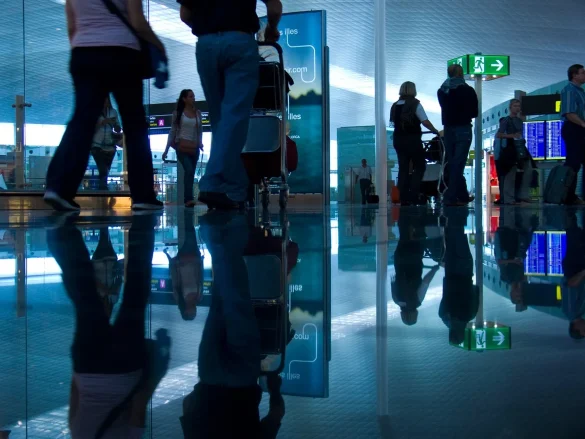 Hall d'aéroport avec tableau d'affichage des vols et passagers en attente