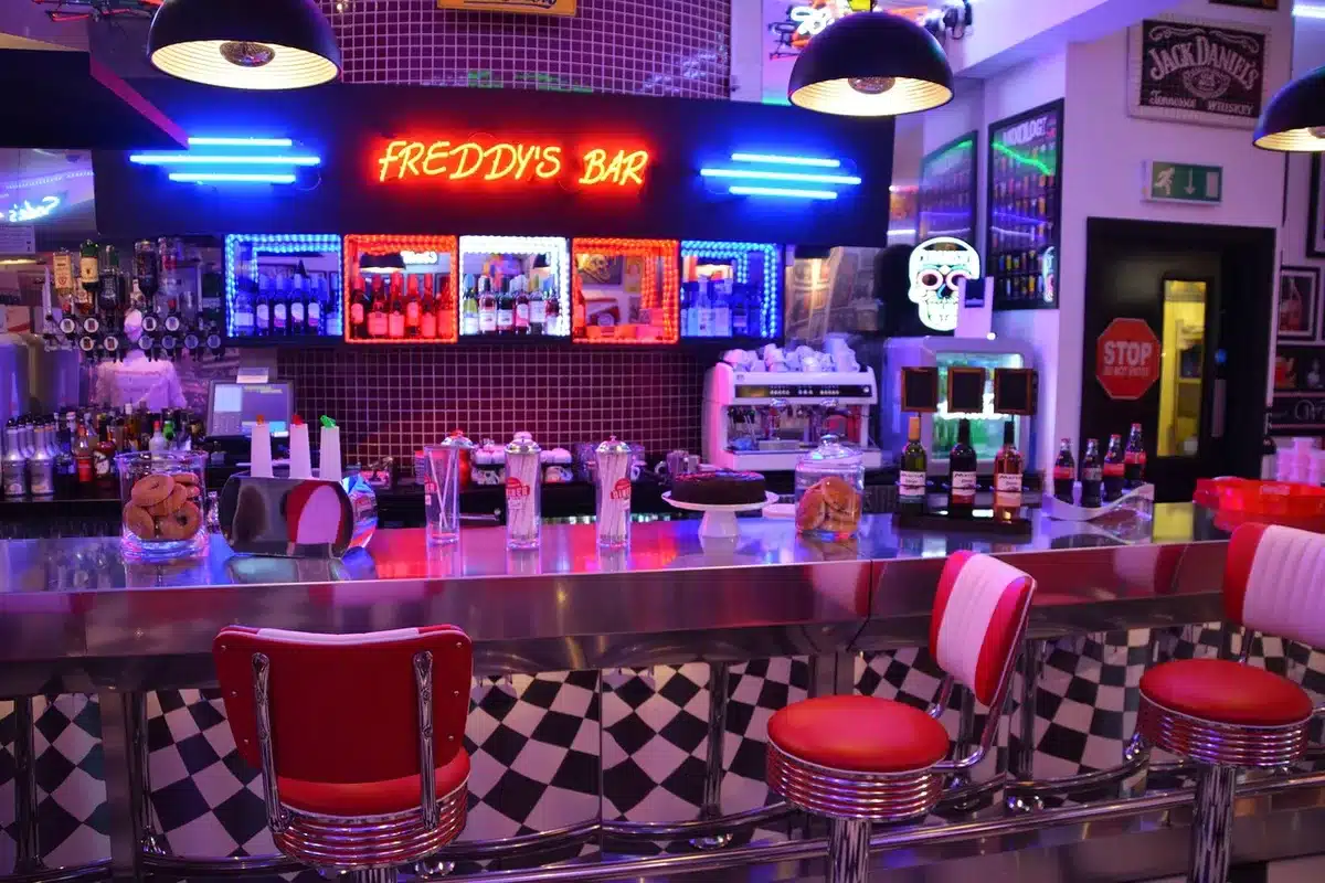 Espace de restauration avec buffet, bar central et préparations culinaires dans un salon aérien