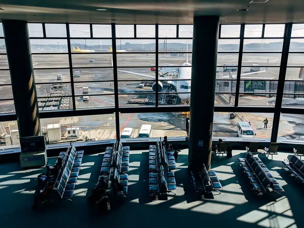 Siège première classe d'avion vide avec écran tactile et plateau, tons gris et bleu
