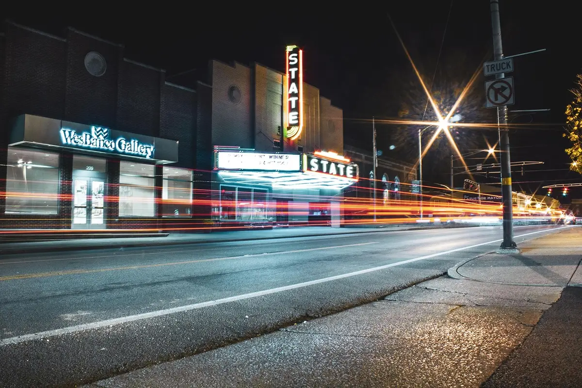 Route urbaine illuminée la nuit avec façades brillantes