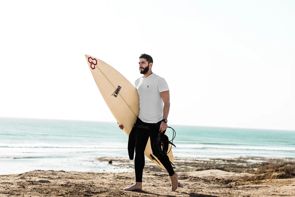 Surfeur débutant apprenant sur une plage de sable avec un instructeur