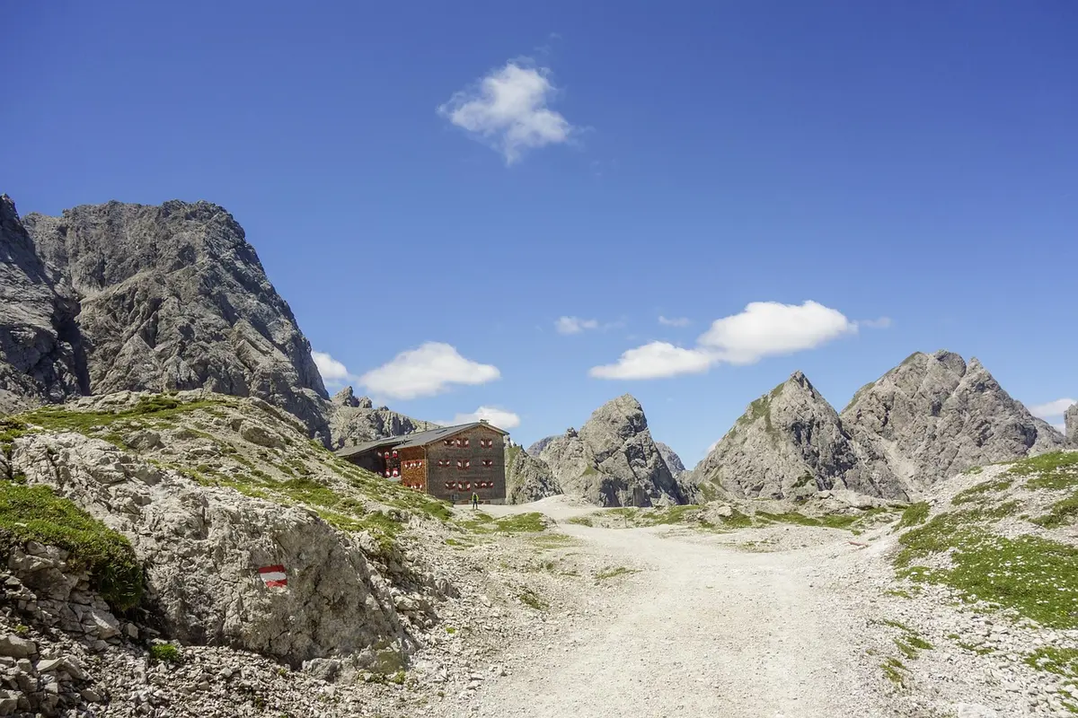 Refuge de montagne entouré de pics rocheux et de prairies alpines dans les Dolomites