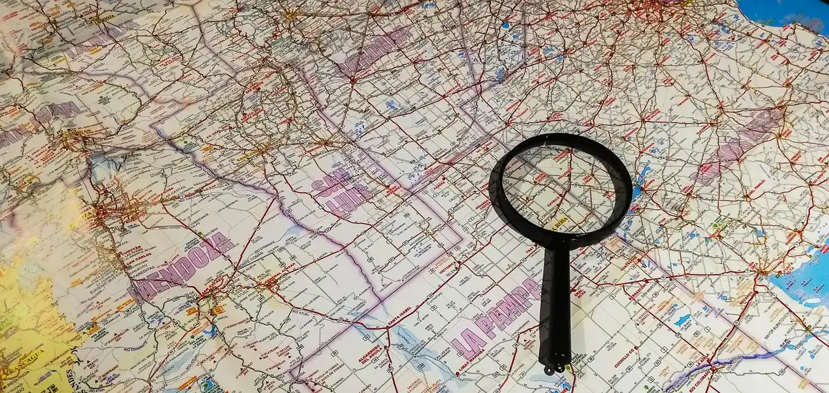 Avion au sol devant un terminal et une carte de routes en arrière-plan illustrant des liaisons transpacifiques