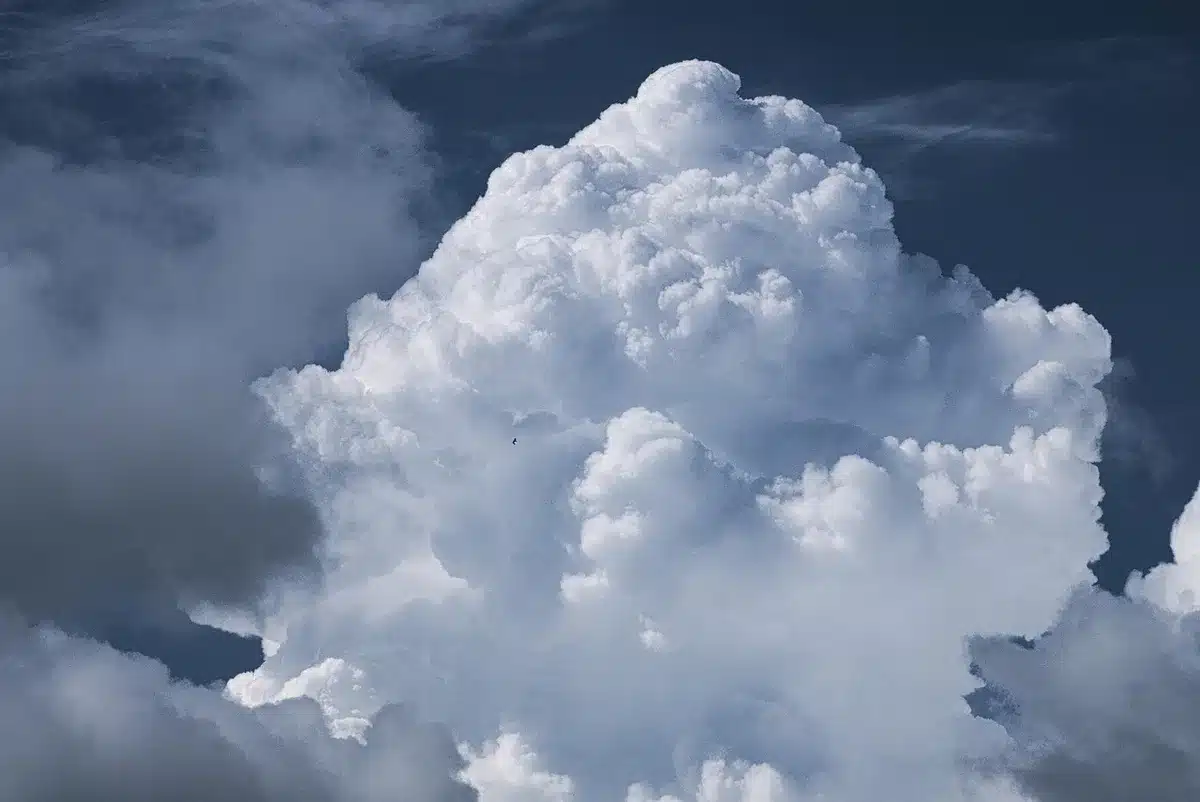 Personne regardant les prévisions météo de montagne sur un smartphone près d'une valise