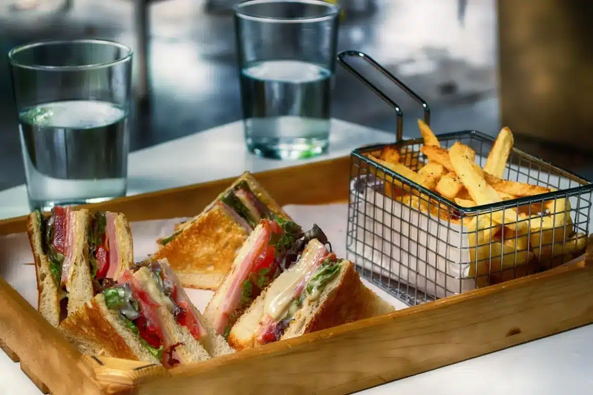 Sandwich de poisson et bol de soupe sur une table de café en bord de mer en plein jour