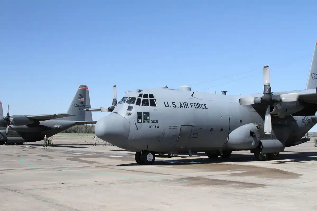 Un hangar d'entretien d'avion avec techniciens et turboprop en journée