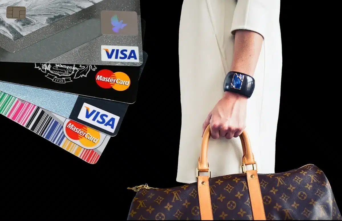 Main tenant une carte bancaire près de l'entrée d'un salon d'aéroport