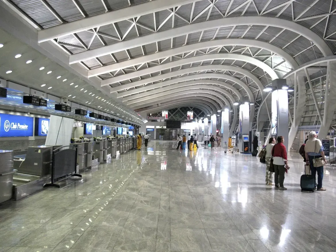 Vue diurne d'une salle d'aéroport face à un chantier de construction et des passagers anonymes