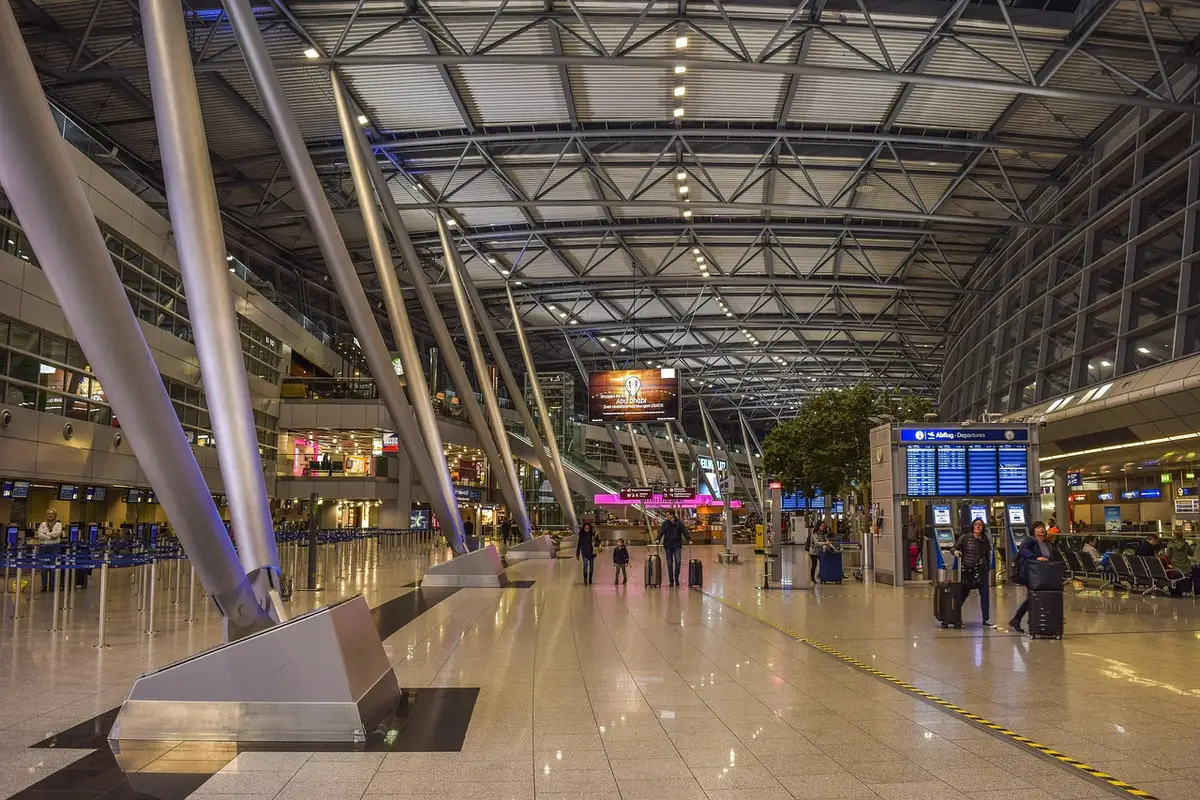 Passager utilisant l'application de la compagnie dans un hall d'aéroport en journée